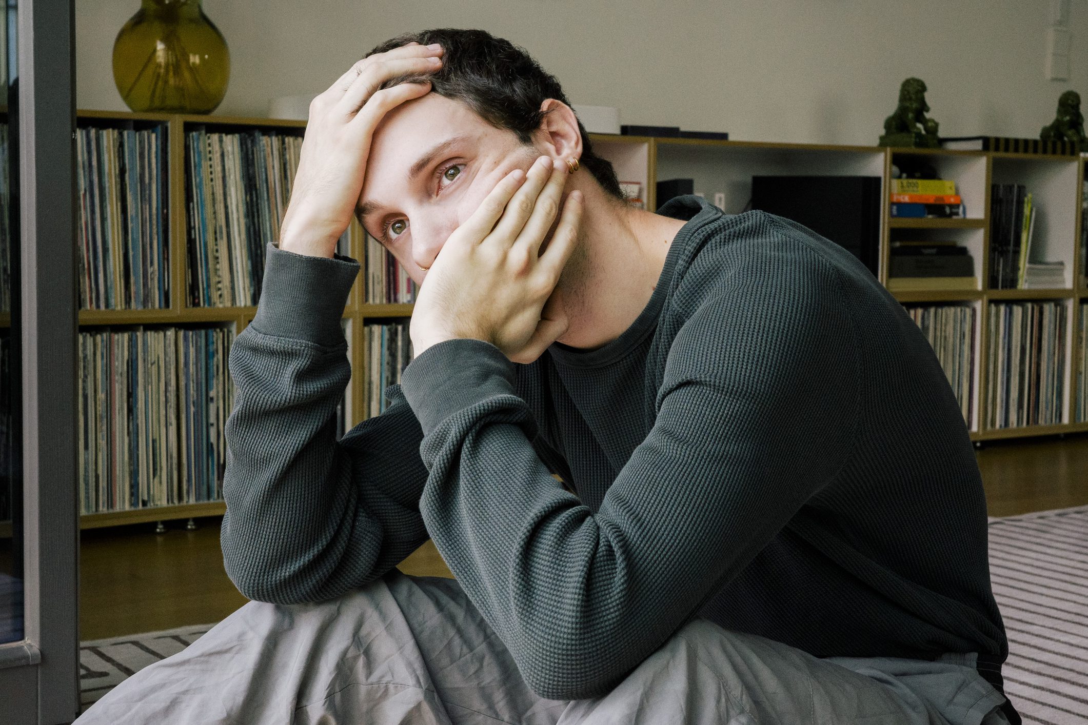 Tattooed arm covering face in stress